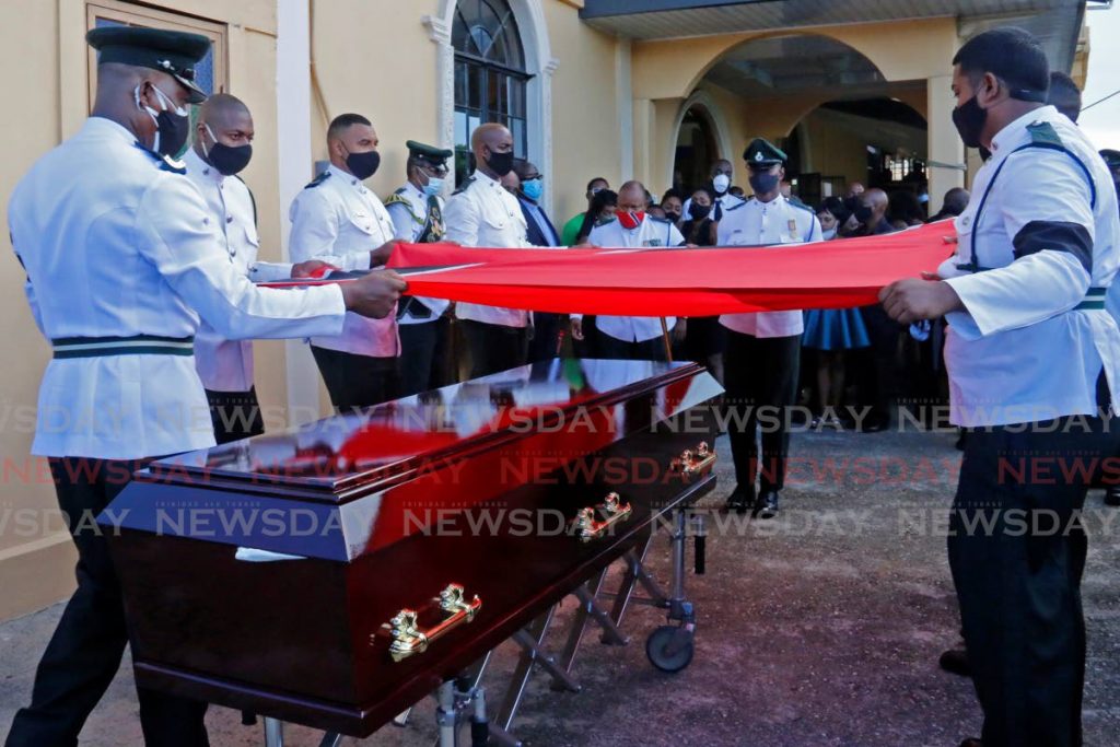 Prisons officers drape the casket of colleague Stephon Richardson with the national flag during his funeral at Mt Pleasant London Baptist Church, Moruga on Saturday. Richardson was gunned down near the church last Sunday. PHOTO BY MARVIN HAMILTON - 