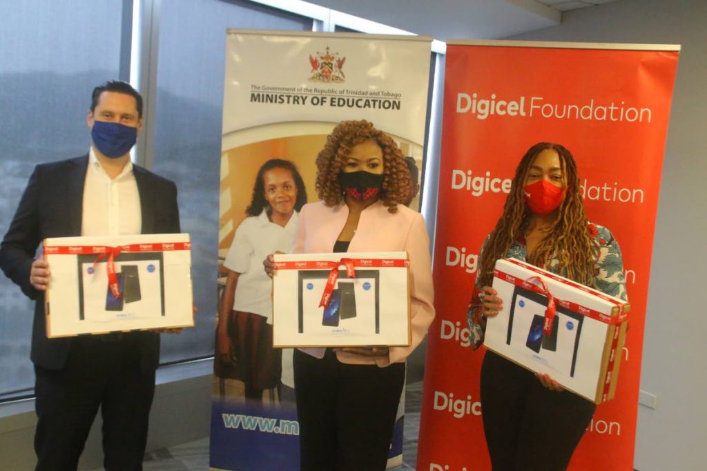Digicel Business General Manager Liam Donnelly, Minister of Education Nyan Gadsby-Dolly Digicel Foundation CEO- Penny Gomez proudly display a couple of the tablets which are being donated to schools throughout TT at a brief handover at the ministry. - Digicel