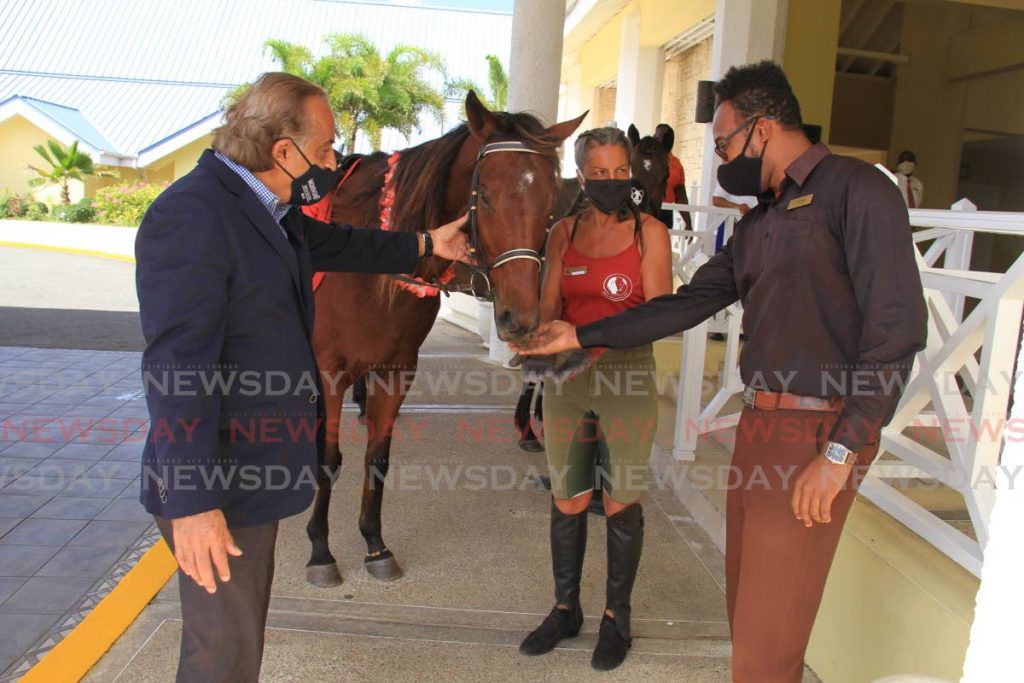 Magdalena Grand Beach and Golf Resort general manager Vinod Bajaj, left, pets the horse Apollo alongside Healing with Horses Foundation founder Veronika La Fortune and bell captain Tiffano Jessop. PHOTO BY AYANNA KINSALE - Marshelle Haseley