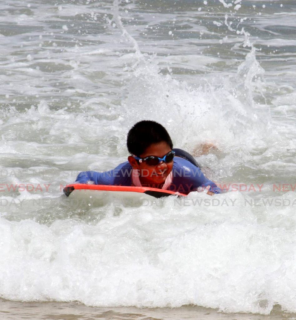 Luke Ragbir 10, body-boards at Maracas Bay on Monday. Beaches were re-opened to the public on Monday. - Angelo Marcelle