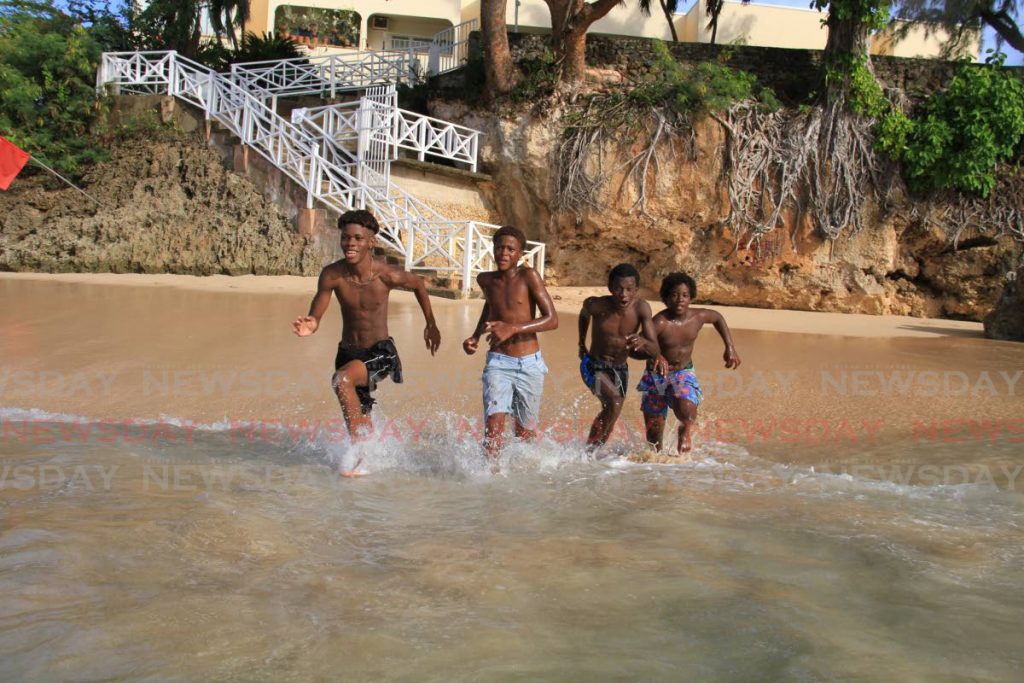 Friends, from left, Keon Baptiste, Stanley Gumbs, Jeremiah Taylor and Jaheem Moses are all excited as they run into the water at Store Bay, Tobago.  - Ayanna Kinsale 