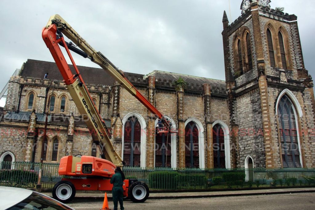 Workers cleaning the guttering of the Cathedral Church of the Holy Trinity in Port of Spain using this articulated boom lift. - SUREASH CHOLAI
