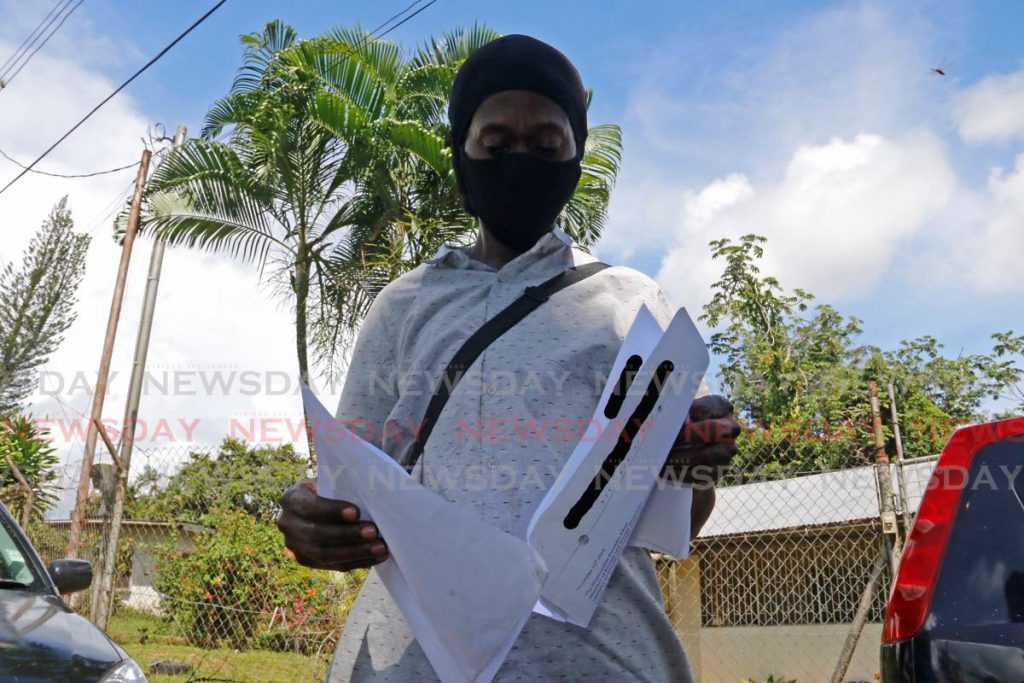 LOOK IT HERE: An evicted resident with his documents which he claimed gave him a right to rent bungalows belonging to Petrotrin in Pt Fortin. PHOTO BY MARVIN HAMILTON - 