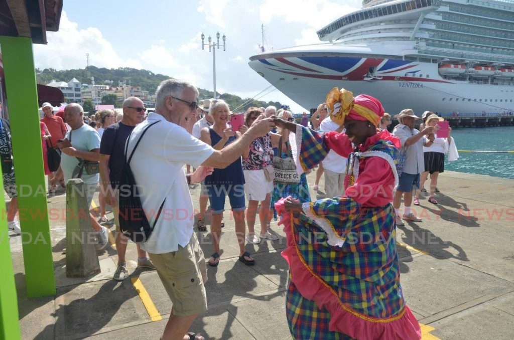 In this 2019 file photo, a visitor from the cruise ship MV Ventura takes some steps with a Tobago dancer as other visitors look on at the Scarborough port, Tobago. The Ventura was on its maiden voyage to Tobago, bringing 2,914 passengers. - FILE PHOTO