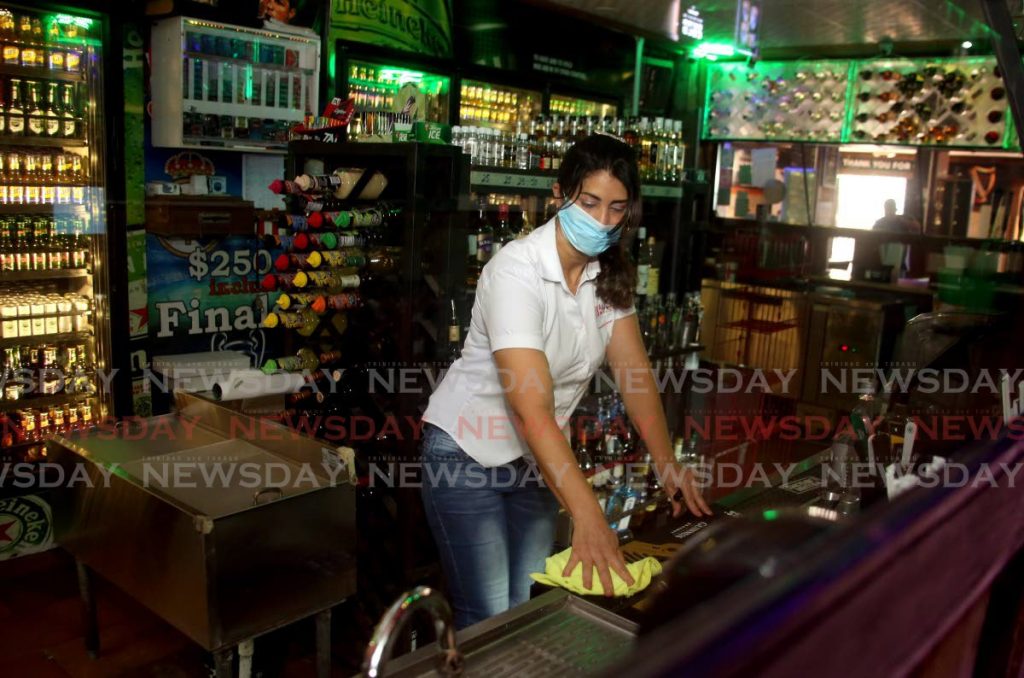 In this September 18, 2020 file photo, bartender Marcy Ledel cleans at Hutt Shutts bar in Tacarigua. The Prime Minister said patrons are still not allowed to drink inside bars. - SUREASH CHOLAI