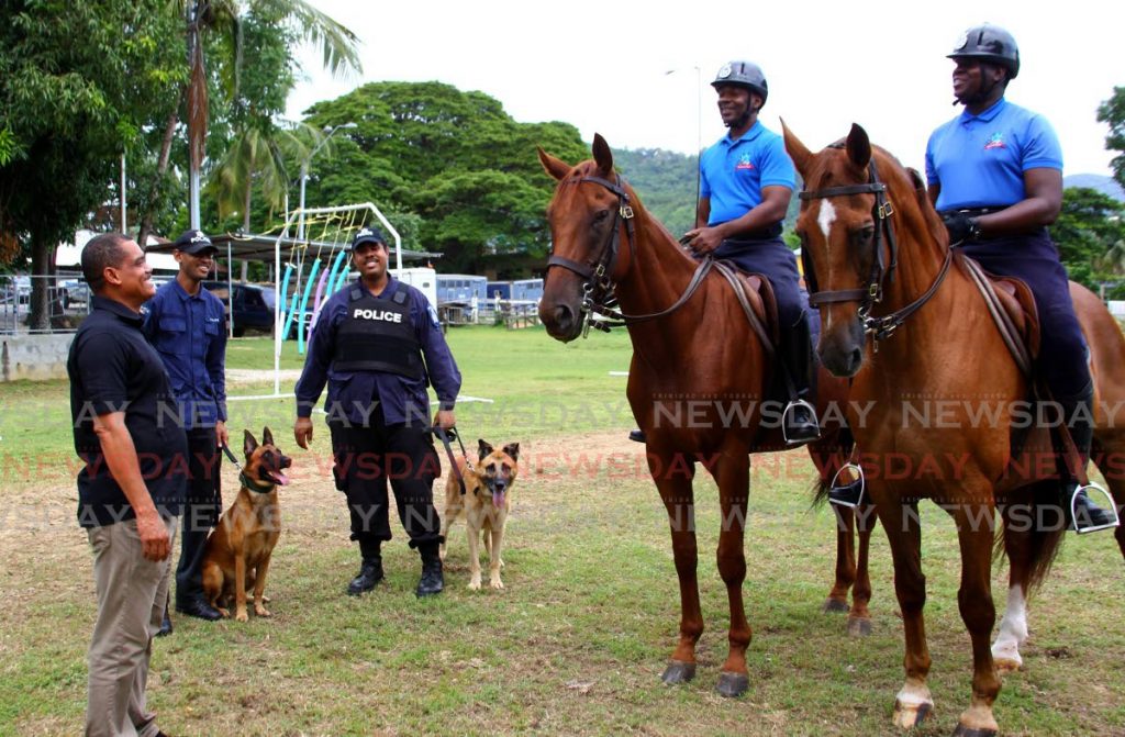  Supt Geoffrey Hospedales, left, speaks to Cpl Kevin Gellineau, right, and Cpl Maurice Williams, second from right, commanding horses Ivan and Hercules, alongside PC Mathew Fountain, second from left, and PC Anderson Charles, third from left, with dogs Nacho and Atom at the Mounted Branch and Canine Unit, St James on October 30. - 
