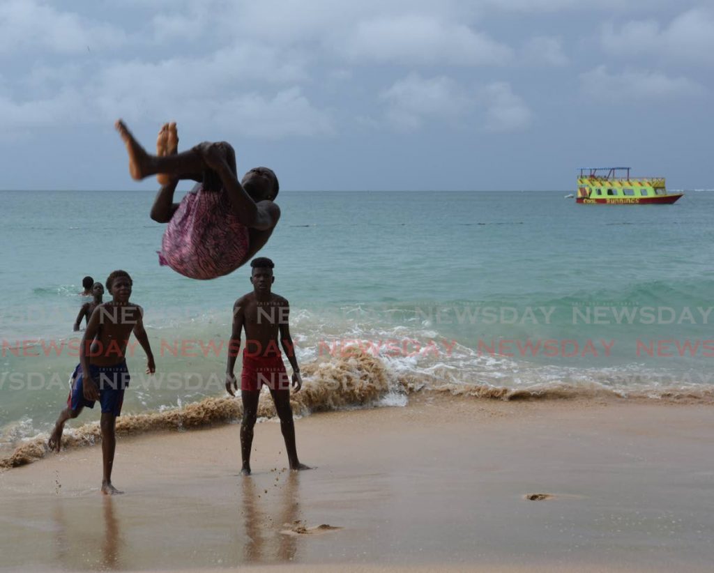 Darius Moore shows off his flipping skills on his friends at Store Bay, Tobago. - Ayanna Kinsale 