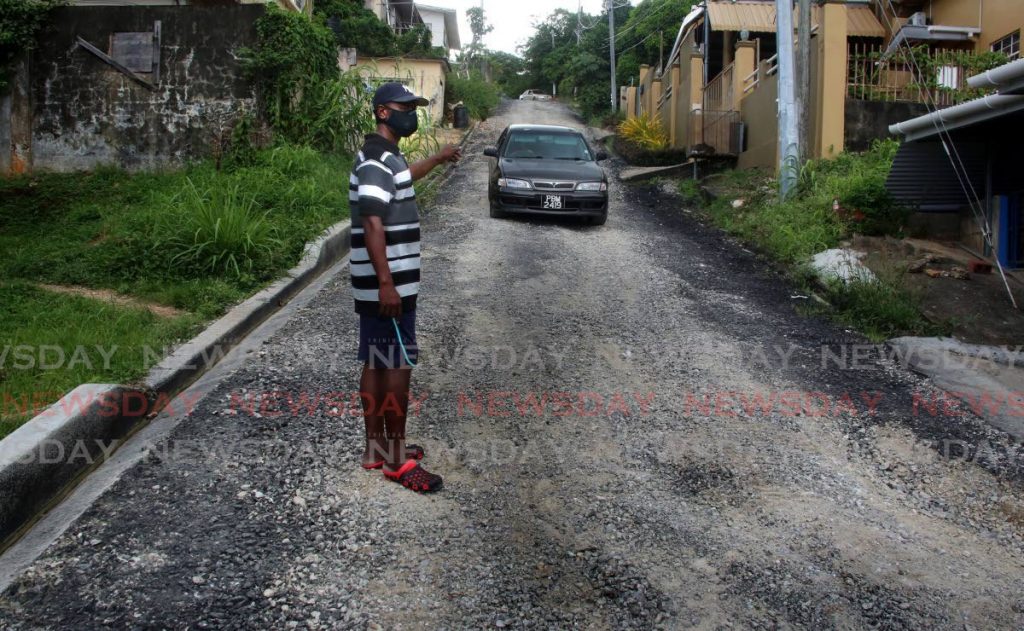 Robert Parris points to the unpaved Thompson Lane in Petit Bourg, San Juan where, since June, roadworks suddenly stopped leaving residents upset. - SUREASH CHOLAI