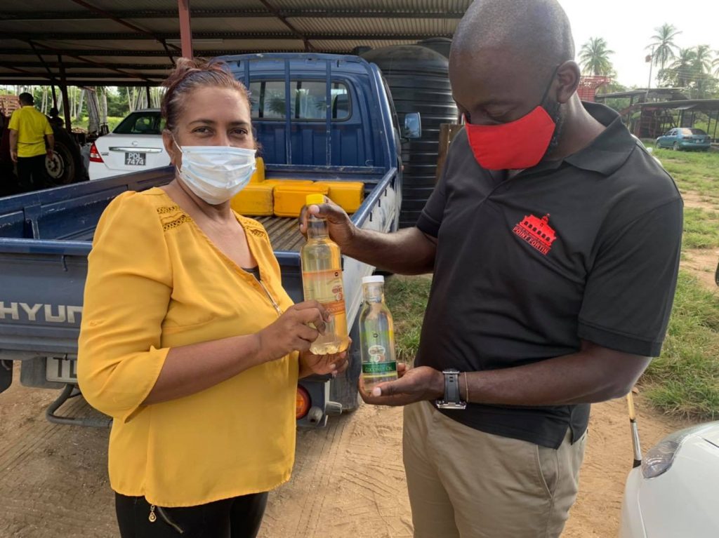 Point Fortin MP Kennedy Richards Jr looks at a bottle of coconut oil manufactured by the Constance Estate in Icacos, Cedros on Thursday. Photo via Facebook.  
