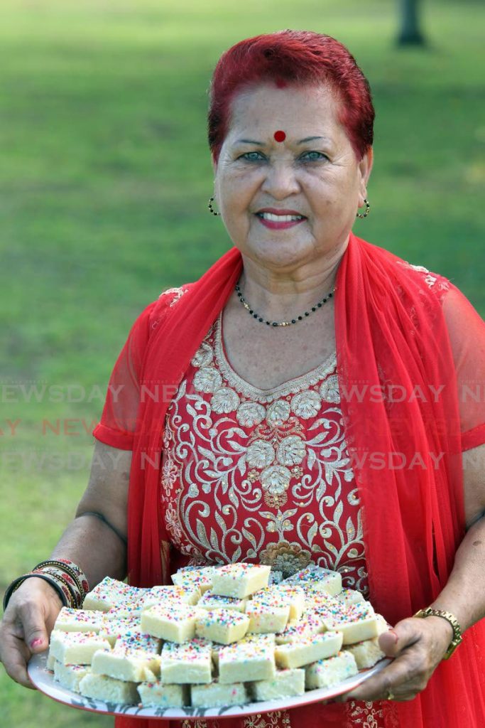 Indra Ramdhan and a tray of milk barfi which she makes for the family business I&M Products. PHOTOS BY LINCOLN HOLDER - 