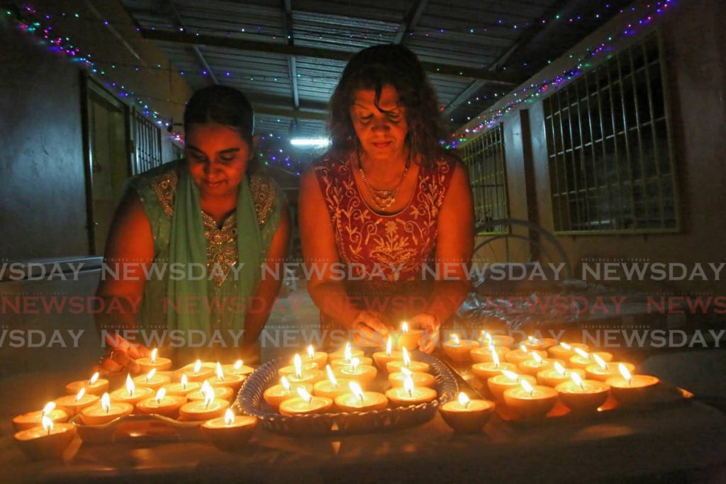 FILE PHOTO: Nadirah and Asha Ramsook celebrating their Divali with lighted deyas to place around their
 home in Cunupia . - SUREASH CHOLAI