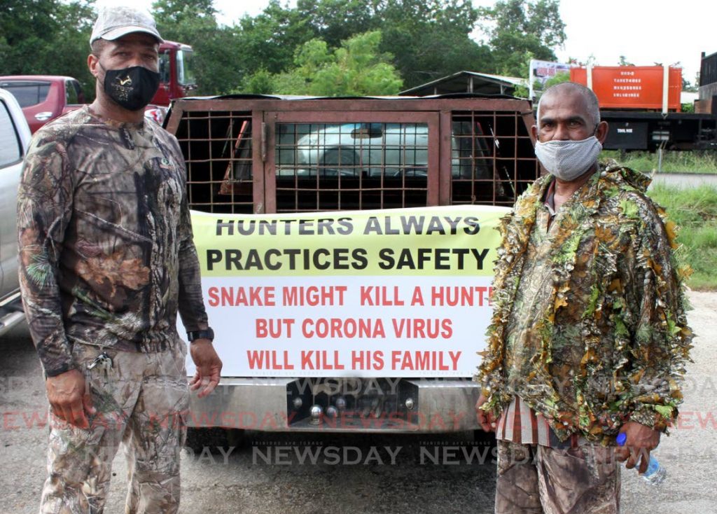 Top Gunz Hunting Association vice president Keith Steele, left, and East Hunting Association member Doodnath Singh stand by empty dog cages at the Caroni Bird Sanctuary car park last Wednesday to protest the suspension of the hunting season. The Prime Minister on Saturday announced the ban on hunting will be lifted. PHOTO BY ANGELO MARCELLE - 
