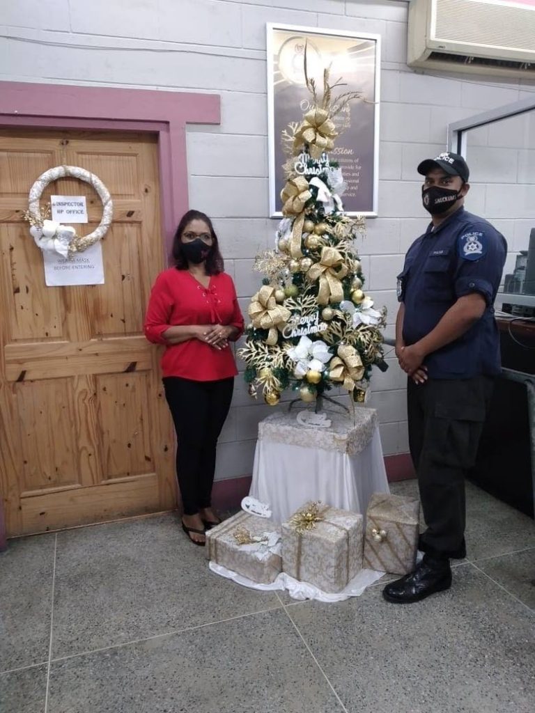 Vandanaa Deonath-Sankar, left, with Coporal Ramroop of the Debe Police Post after she decorated the station on November 15.  - 