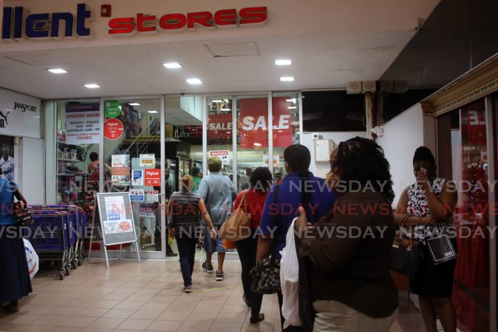 People line up outside Excellent Stores City Centre mall off Frederick Street on Friday to participate in a closing down sale. PHOTO BY SUREASH CHOLAI - 