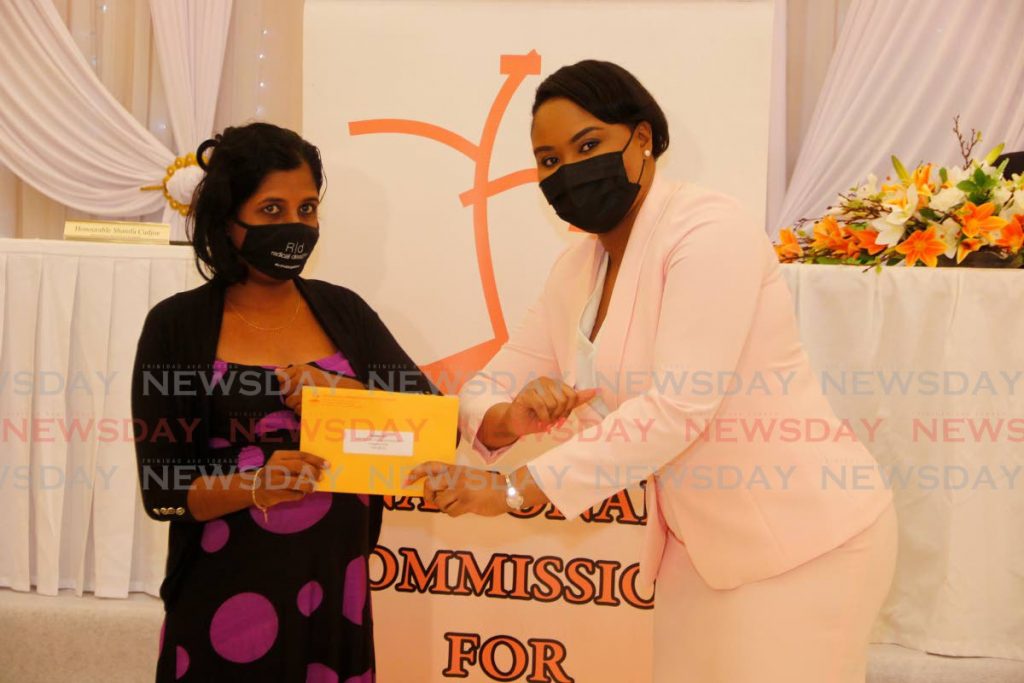 Sport and Community Development Minister Shamfa Cudjoe presents Susan Ali with a self-help grant at Signature Hall, Montrose, Chaguanas on Friday. PHOTO BY MARVIN HAMILTON - 