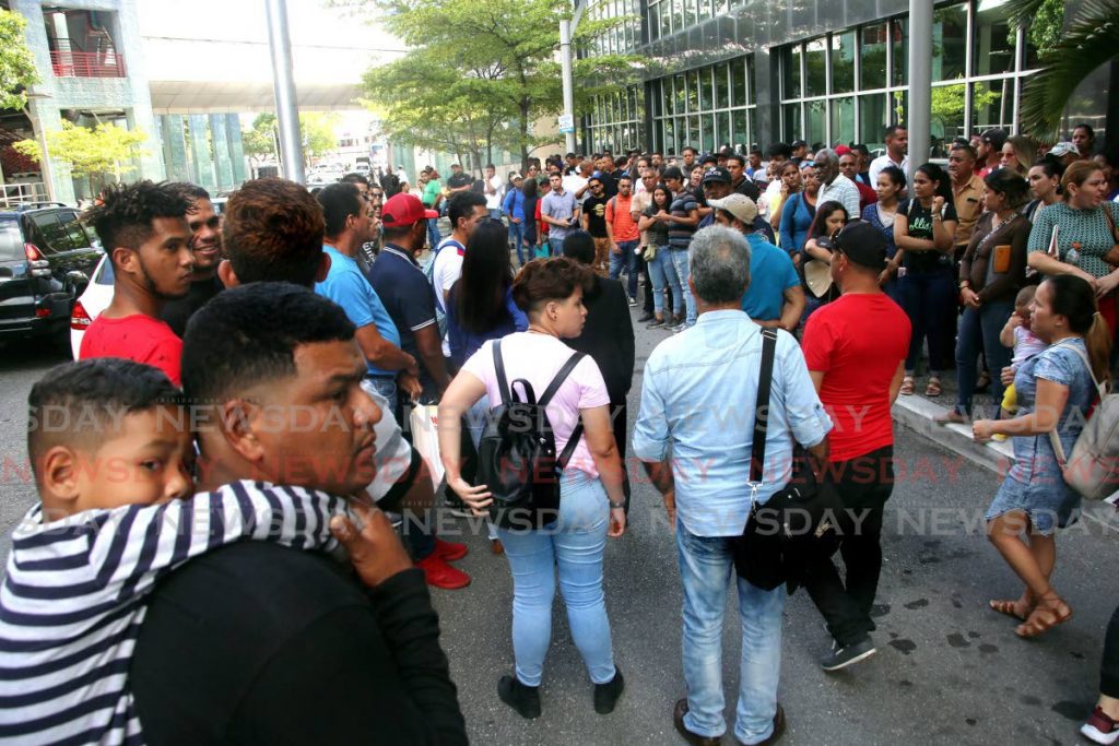 In this 2019 file photo, Venezuelans line up  to collect their registration cards outside the Ministry of National Security building on lower Richmond Street in Port of Spain. - SUREASH CHOLAI