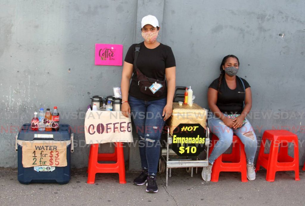 
Venezuelans Diannis Herrera and Carol Romero wait for customers to arrive to buy coffee and empanadas in Chaguanas. Herrera has a food badge and sells the empanadas which Romero makes along with the coffee and drinks  she supplies. PHOTO BY ANGELO MARCELLE
 - 