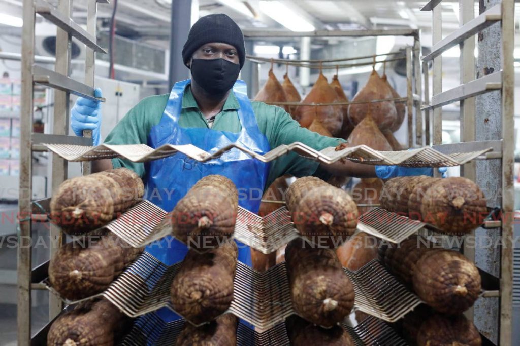 An Erin Farms employee pushes a trolley with packaged Black Forest turkey ham at the company's processing and packaging unit in St Francis Village. - Marvin Hamilton