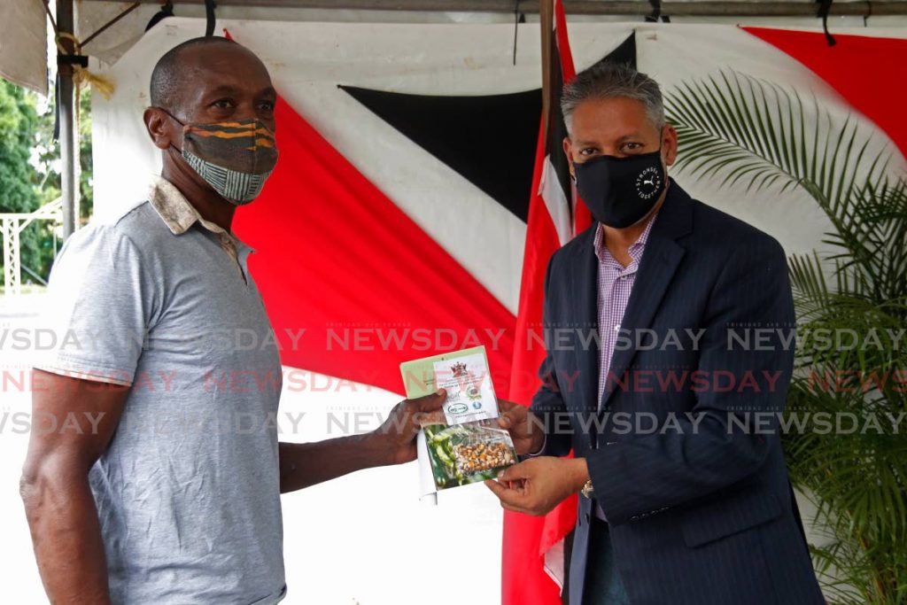 Dexter Stewart, left, recieves a package for the Grow Your Own Food Drive from Minister of Agriculture, Land and Fisheries Clarence Rambharat, an innitiative by the Point Fortin Borough Counci, on Monday morning Fanny Village Recreation Ground. - Marvin Hamilton