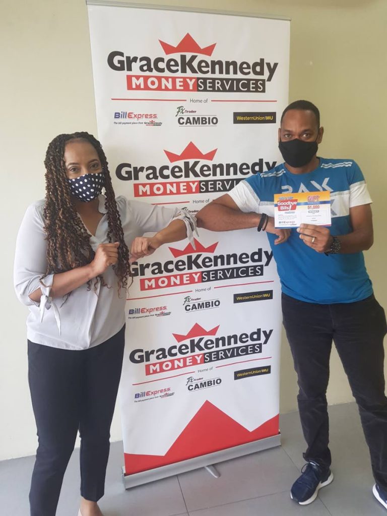 BIDDY WINS: GraceKennedy (TT) Operations Manager Paulette Garcia with Goodbye Bills promotion grand prize winner Anthony Dinsley Biddy who won vouchers to cover six months worth of bill payments. PHOTO COURTESY GRACEKENNEDY (TT) LTD - 