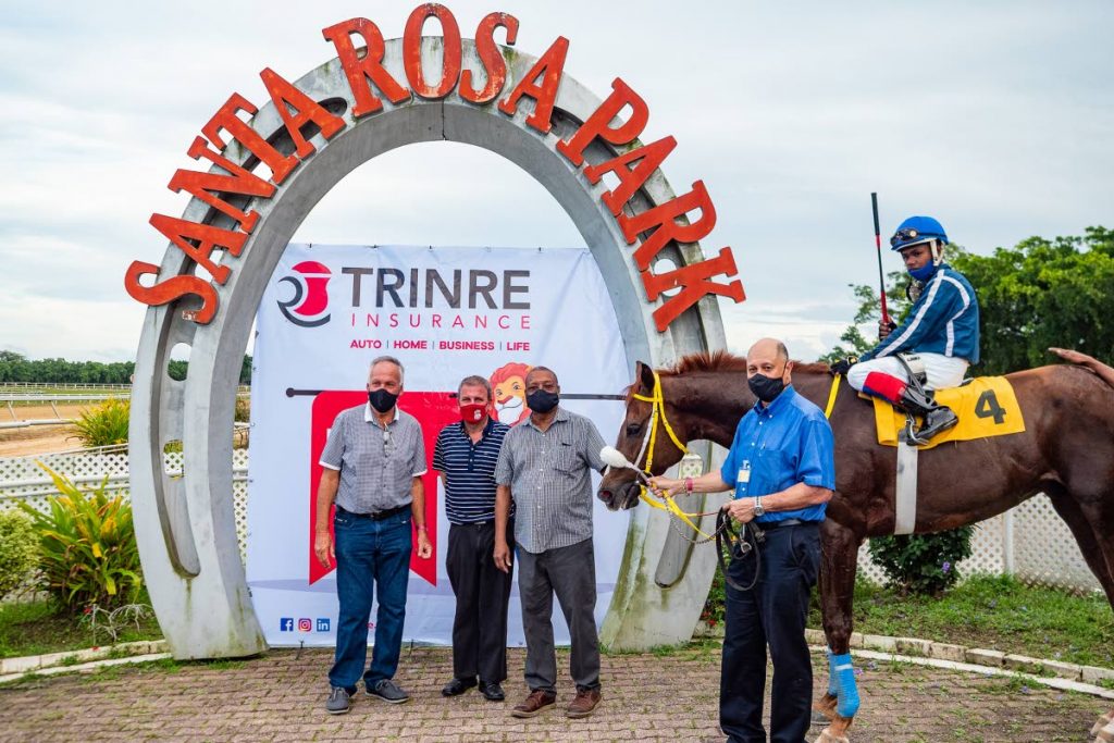 Neil Poon Tip (right), Gerry Harding (second from right) and Roger Hadeed (second from left) of owners PT Racing Group, trainer John O’Brien (left) and jockey Kimal Santo aboard the winning horse, Triple Crown winner Wise Guy, after their victory in the TRINRE Trinidad Derby Stakes on Saturday.  - 
