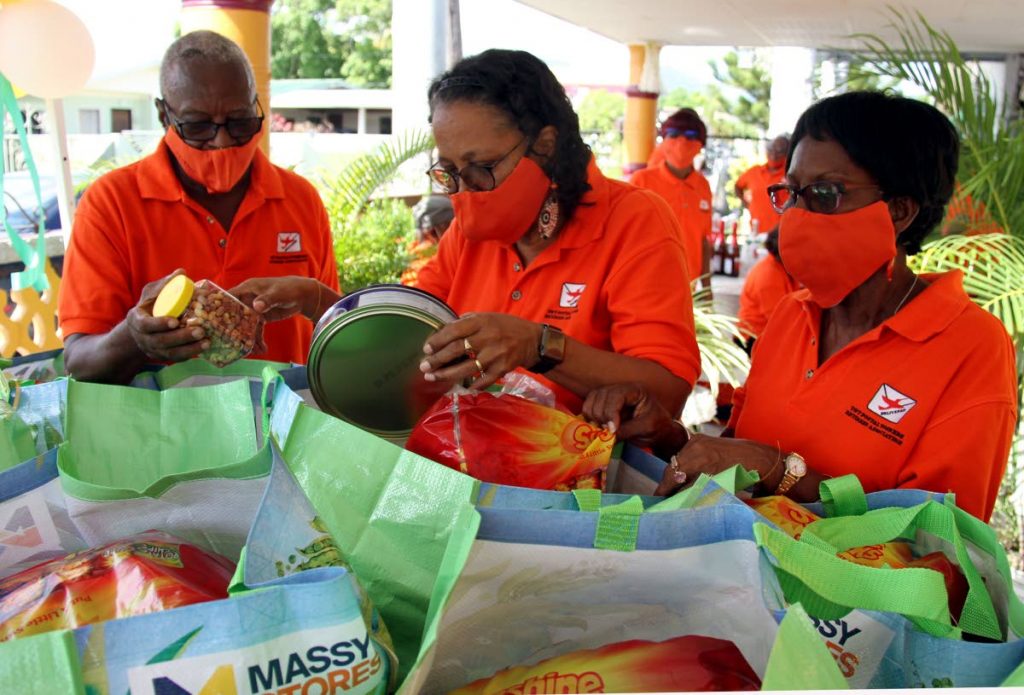 President of the Trinidad and Tobago Postal Workers Retiree Association Jean Romeo, right, and Vice President Joey McLean assists PRO June Laing-Williams in packing a hamper for the needy on Subero Street, Malabar. 2020.12.02  - Ayanna Kinsale