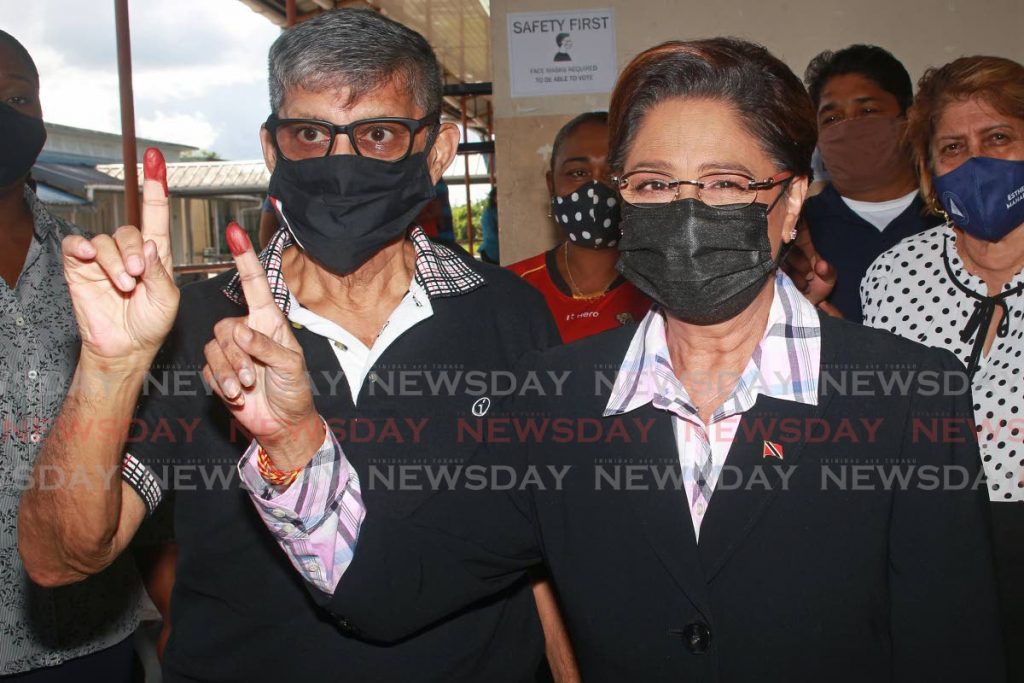 Political Leader of the UNC Kamla Persad-Bissessar  and her husband Dr Gregory Bissessar display their fingers after voting in the party's internal election at Parvati Girls' Hindu College, Debe, on Sunday. - CHEQUANA WHEELER