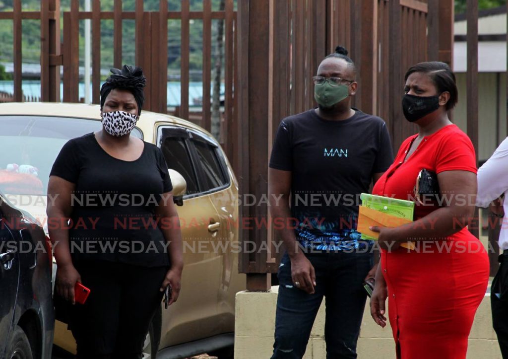 From left Candice Riley, the victim's mother, cousin Roland Riley and Lisa Riley, aunt,  look on as Lenwin Barrow, father of the victim, leaves the Forensic Sciences Centre in St James. The family was there to officially identify if the body discovered last Friday, in the forested area in Upper La Canoa was that of the teenager, Ashanti. Forensic Sciences Centre, St James. - ROGER JACOB