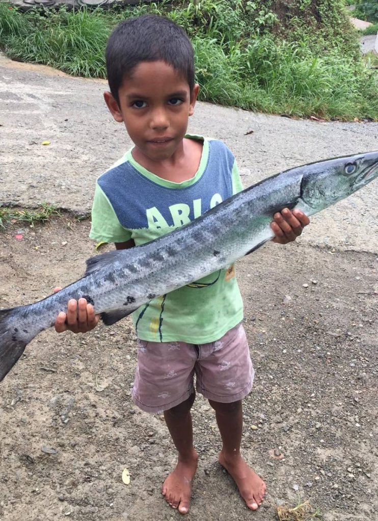  Jonathan Edmund holds a blue bone fish which he helped to catch. 
PHOTO COURTESY KUMARIE PERSAD  - 