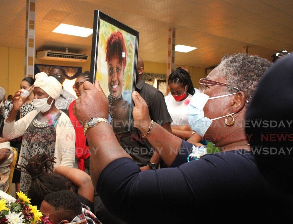 A relative of Krystal Primus-Espinoza, stares at a photograph of her. - 