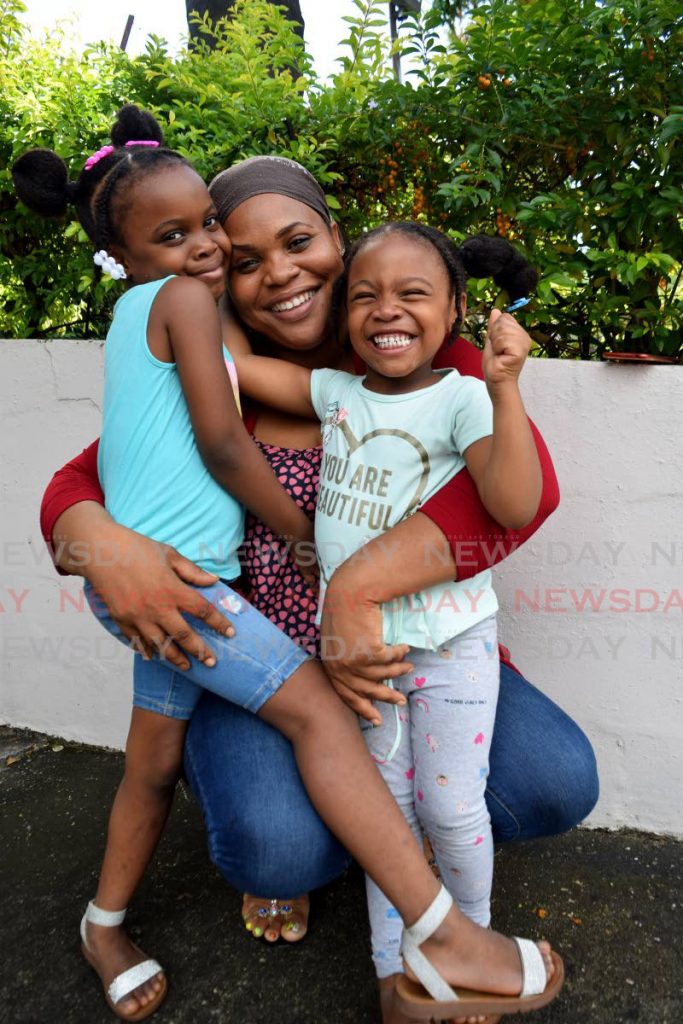 Heaven Bliss owner Akeila Dalrymple shares a fun moment with her daughters six-year-old Avaniyah, left, and four-year-old Avaria Lawrence at the UpMarket, Lions Cultural Centre, Woodbrook, on December 6, where she had a organic food products on sale. - Vidya Thurab