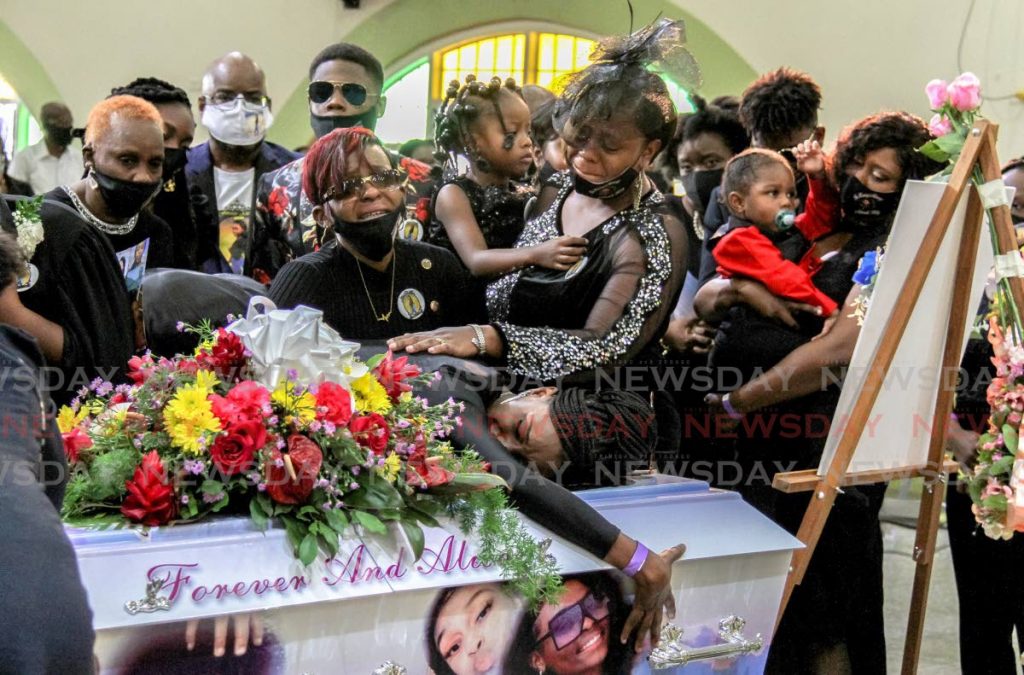 OVERWHELMING GRIEF: Aaliyah Riley, sister of murdered Ashanti Riley, hugs the coffin during her funeral at the Mt D’Or SDA Church on Monday. - AYANNA KINSALE
