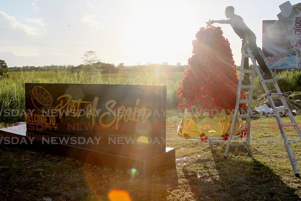 Christian Jaggernauth of OINK- Outdoor Images N Kaleodoscope Advertising Company, places the  traditional star ontop the christmas tree, as part of the final touches during the unveiling of the 