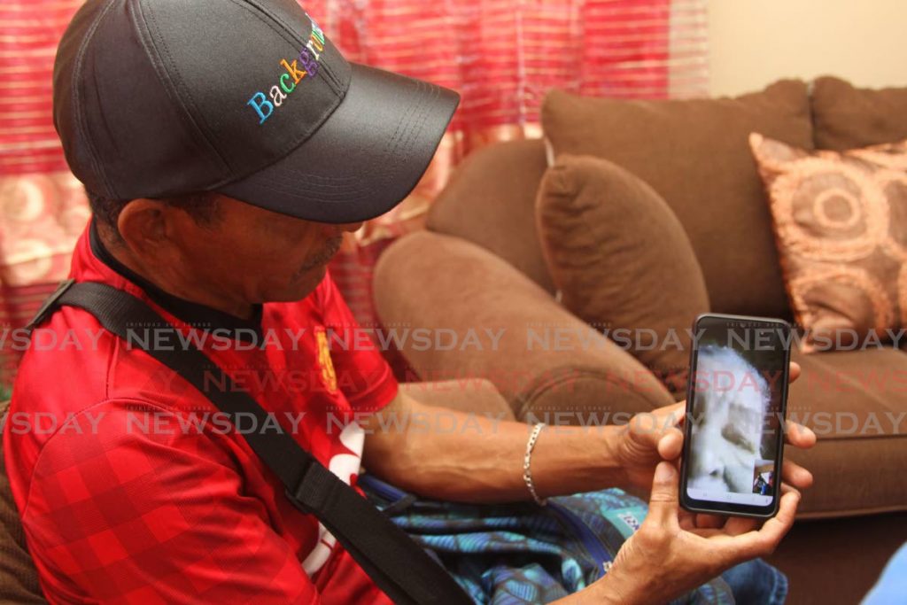 From his home in Central Trinidad, this migrant chats with his mother who is in Venezuela on Wednesday. He believes his wife and 10-year-old son were among 23 people who drowned in the sea off Guiria on the weekend while trying to reach Trinidad. - Lincoln Holder