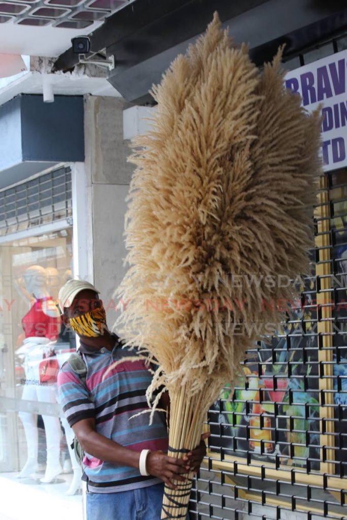 Winston James is seen selling these sugar cane stalks he calls roso cane, on Frederick street  in Port of Spain that many used to decorated their homes for Christmas. - Sureash Cholai