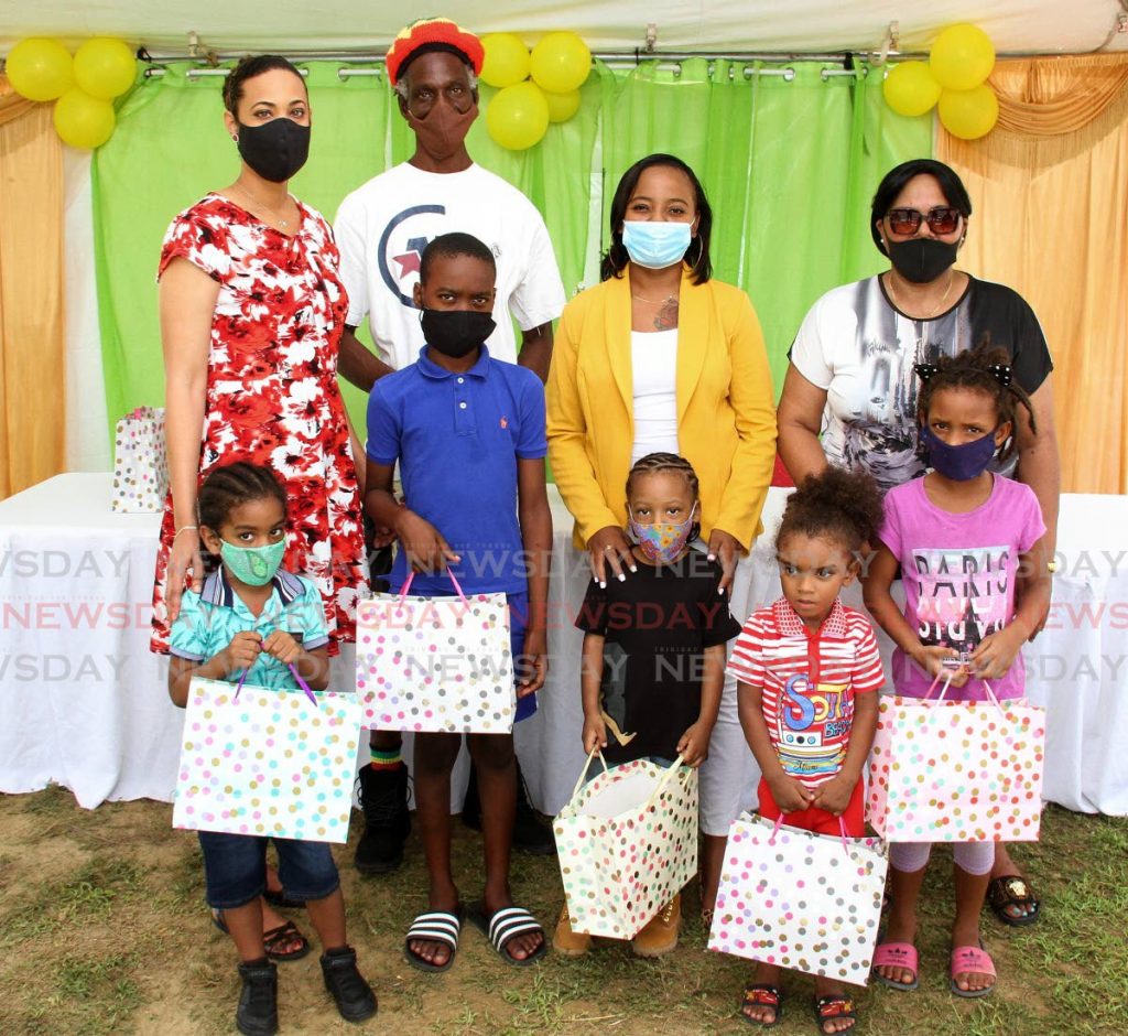 St Augustine MP Khadijah Ameen, left, poses with members of the Oropune Elders and six children who received tablets on Saturday. - Angelo Marcelle