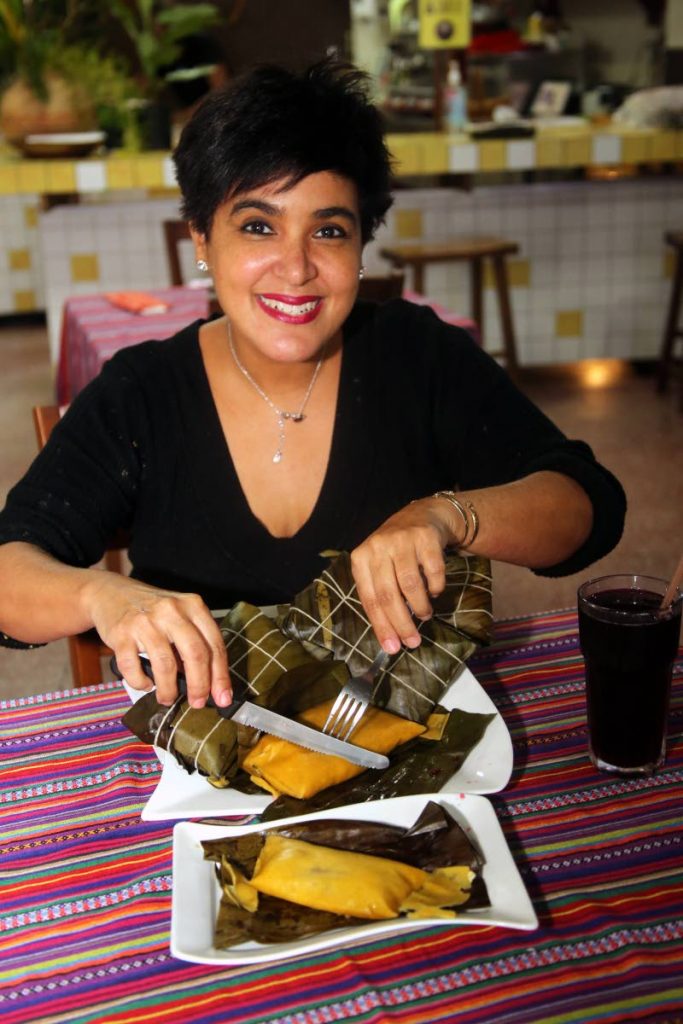 Taryn Cumberbatch cuts a hallaca to show its thickness compared to the pastelle plated at front. Taryn Cumberbatch holds several hallacas which are similar to pastelles but are thicker. PHOTOS BY SUREASH CHOLAI

 - 