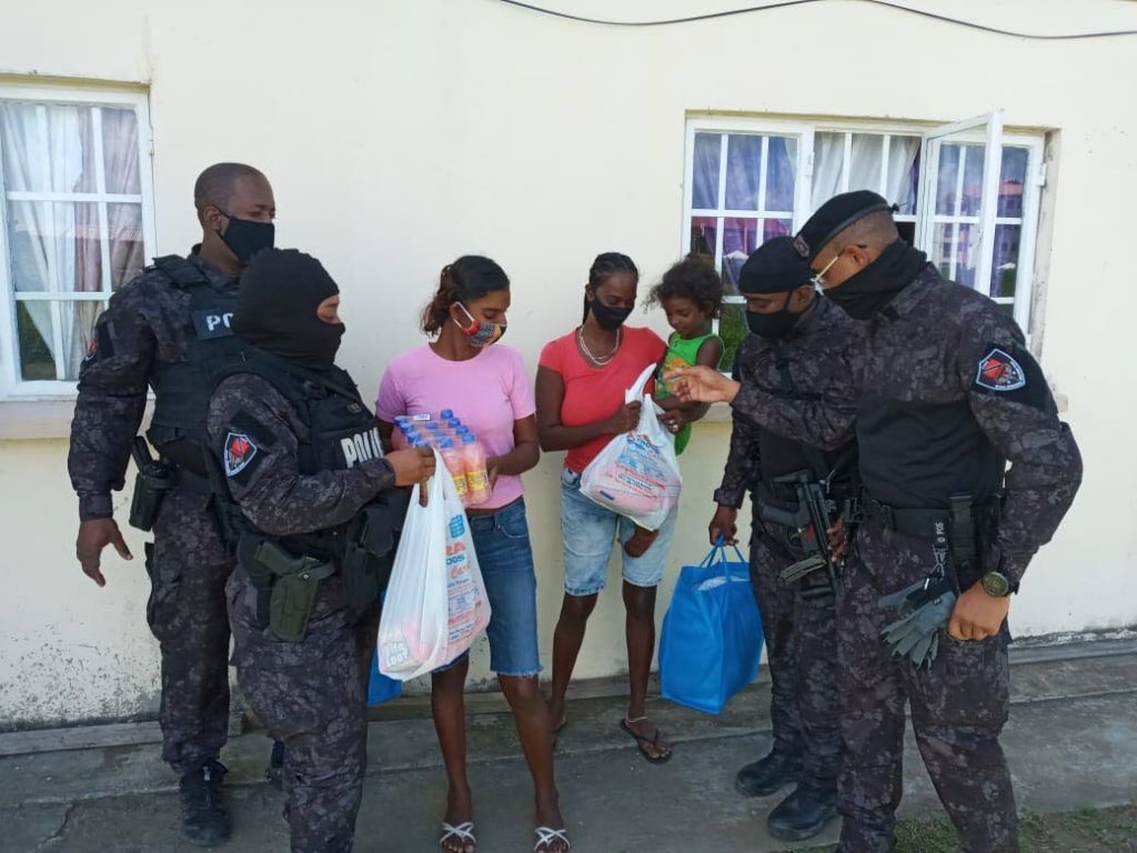 Members of the Special Operations Response Team delivers food hampers to families in Maloney on Thursday. 
The hampers were donated by businesses and the initiative was coordinated by the police. PHOTO COURTESY TTPS - PHOTO COURTESY TTPS