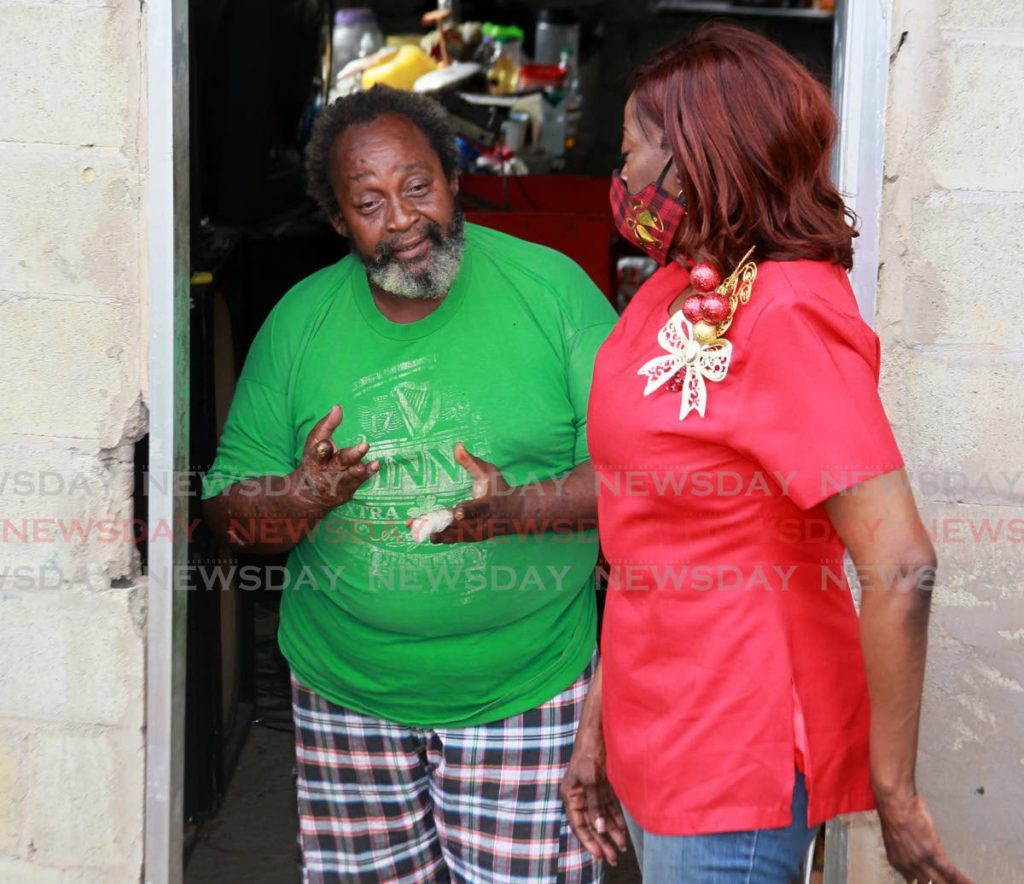 Lucien Joseph who suffers with Buerger's disease – an inflammatory and blood disorder – speaks to Minister of Social Development and Family Services Donna Cox during an outreach programme in San Juan on Christmas Day. PHOTO BY ROGER JACOB - 