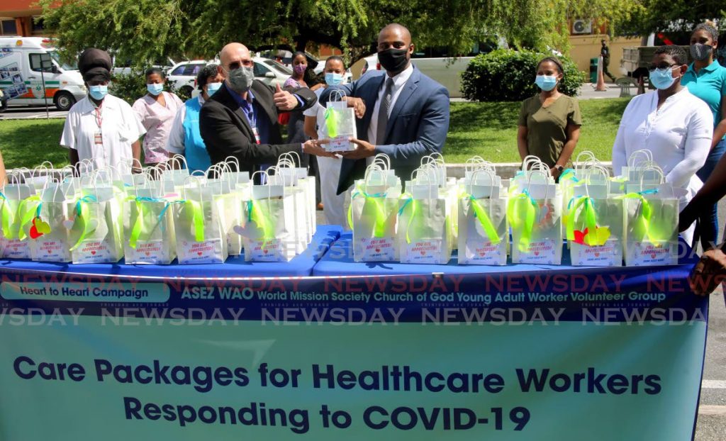 North West Regional Health Authority (NWRHA) medical director Dr Paul Antony Parkinson (left) received one of 60 care packages for staff members at the Port of Spain General Hospital from Deacon Michael Duncan of World Mission Society Church of God Young Adult Worker Volunteer Group ASEZ WAO. - Sureash Cholai