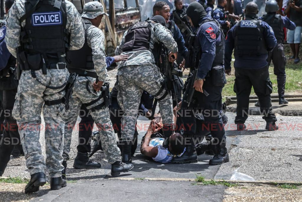 FILE PHOTO: Police subdue a protester during unrest in East Port of Spain on June 30 over the police-involved killings of three men in Morvant three days earlier. - Jeff Mayers