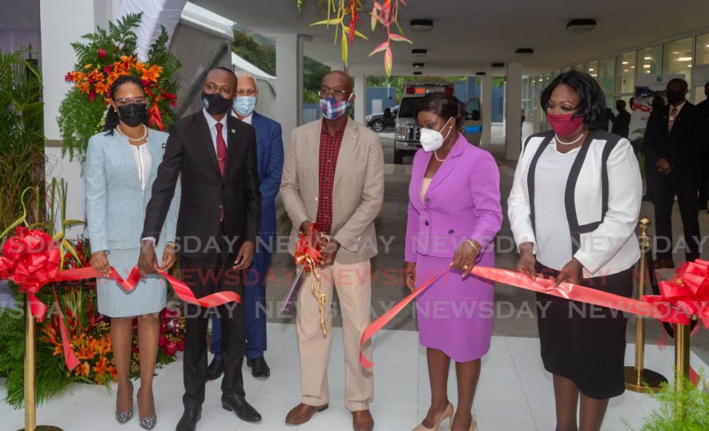 Prime Minister Dr Keith Rowley, centre, cuts the ribbon to officially open the Roxborough hospital at Bloody Bay Road, Roxborough, Tobago on Tuesday. - DAVID REID 