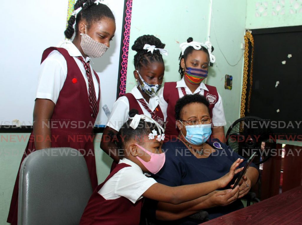 In this file photo, Laventille Girls' Government Primary School student Merci Murray points to a class exercise on her tablet while her principal and classmates look on. Photo by Ayanna Kinsale