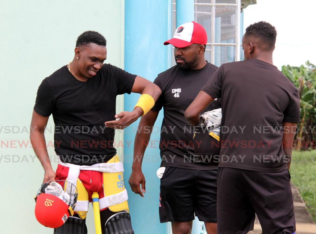 TT Red Force cricketer Dwayne Bravo, left, articulates a batting stroke to his brother Darren Bravo, centre, and Keagan Simmons during a training session at the National Cricket Centre, Couva, on Friday. PHOTO BY ANGELO MARCELLE - Angelo Marcelle