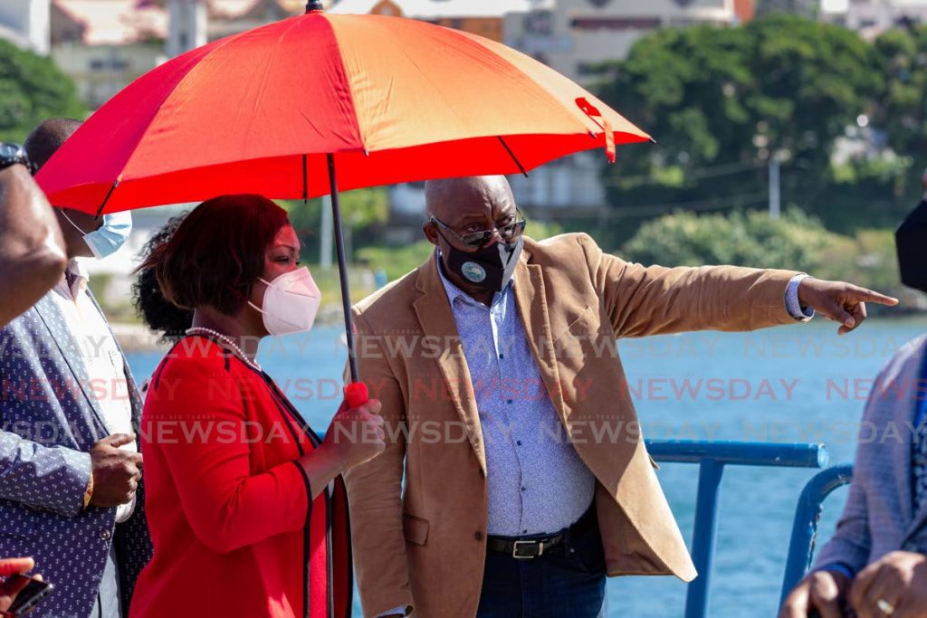 SUN 
SHELTER: Tobago PNM Council political leader Tracy Davidson-Celestine shelters from the sun under an umbrella on Friday during the arrival of the APT James fast ferry at the Scarborough Port. 
PHOTO BY DAVID REID - David Reid