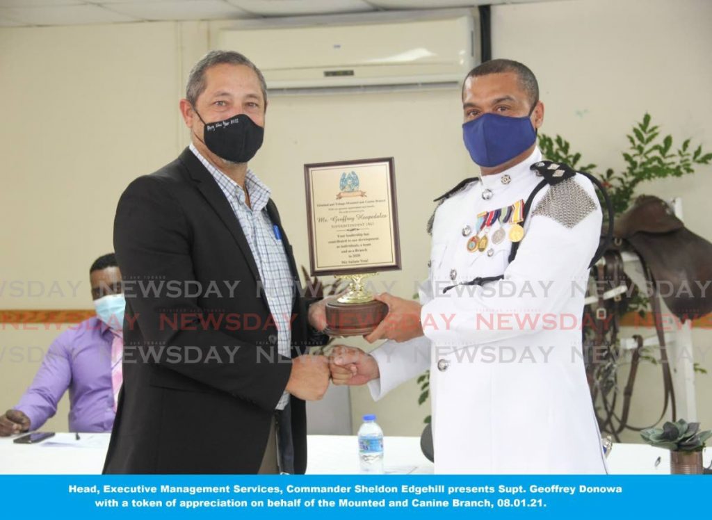 Head of Executive Management Services Cmdr Sheldon Edghill, left, presents Supt Geoffrey Hospedales with a token of his appreciation during a graduation ceremony for officers of the police Mounted and Canine Branch on Friday. 

PHOTO COURTESY TTPS - PHOTO COURTESY TTPS