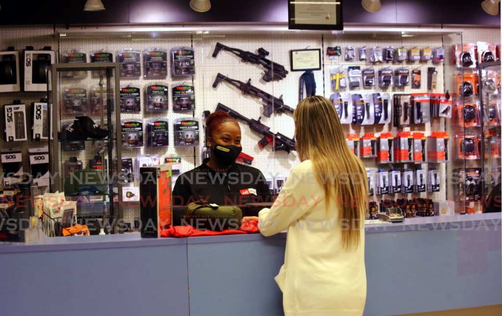 A woman makes a purchase at AE Tactical Store, Trinicity Industrial Estate. - Photo by Sureash Cholai