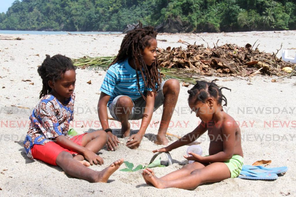Brothers Tafa 6, Ahriseza 11 and Guidah 3, play in the sand on Grande Riviere Beach on Monday morning. - Angelo Marcelle