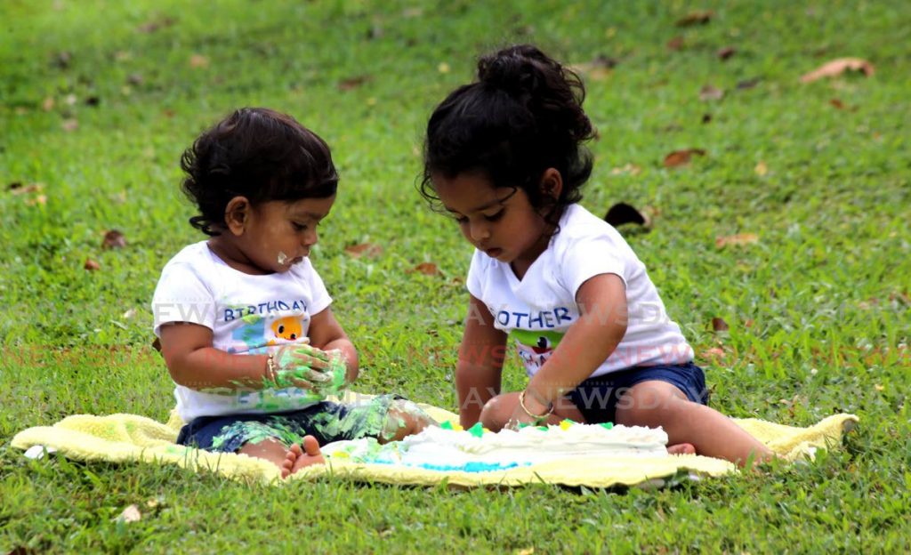 Ethan Ramsaran left with his brother Marcus Ramsaran , frolic with Ethan's first year  birthday cake,  at  the Royal Botanical Garden in Port of Spain. - SUREASH CHOLAI