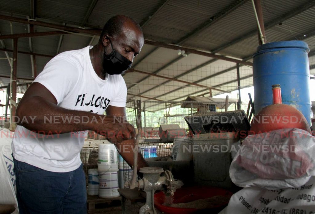 In this file photo, farmer Andy wears grinds pellets to feed his chickens as the usual supply of poultry ration was unavailable. - 